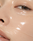 Close-up of a model wearing a transparent hydrogel face mask on the skin