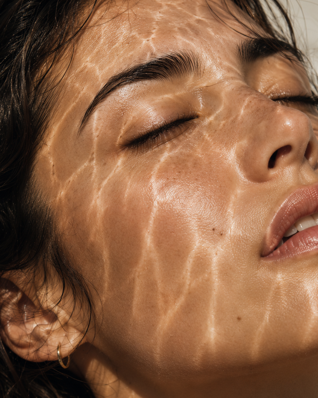Close-up of a woman's face with sunlight reflecting like water