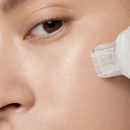 Close-up of the Roller Gold micro-needle device gently applied to the cheek for targeted skincare treatment